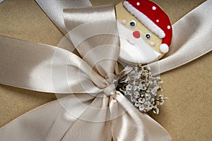 Close up of a Christmas or New Year brown gift box with champagne gold color ribbon