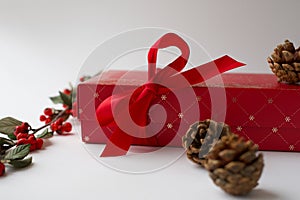 Close-up of Christmas present with a bow in white background. Details of beautiful red gift box