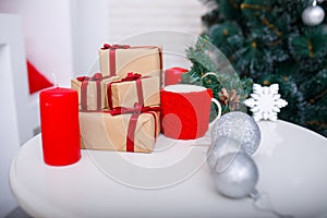 Close-up of Christmas presents on a table in front of a Christmas tree.