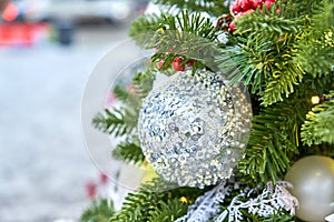 Close up of christmas tree decorated with silferr sparkling balls and garland with lights on. Festive background with copy space