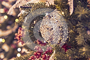Close up of christmas tree decorated with silferr sparkling balls and garland with lights on. Festive background with copy space