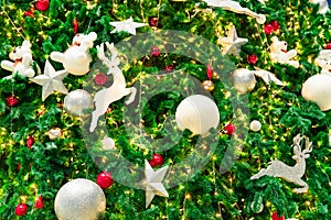 Close up Christmas tree decoration with red, gold, silver, and white balls, silver star and white reindeer. Xmas background.