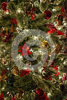 Close up of a christmas tree ornaments baubles ribbons flowers and lights. Christmas card background wallpaper concept