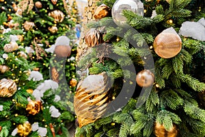 Close up of christmas trees decorated with sparkling balls and garland with lights on. Festive background with copy space for your