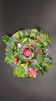 Close-up on a Christmas wreath, candles and various decorations on a dark background