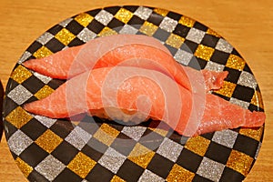 Close up of chutoro tuna sushi nigiri on plate in sushi belt japan