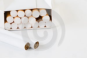 Close-up of cigarettes in pack on white background with copy spa