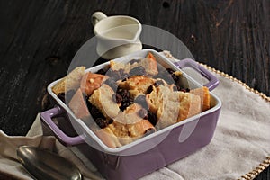 Close Up Cinnamon Bread and Butter Pudding with Raisins in Clear Baking Dish, Served with Vla