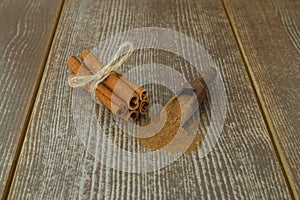 Close up cinnamon sticks and cinnamon powder in wooden spoon on wooden table background, healthy spice concept