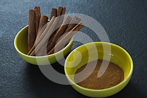 Cinnamon sticks and powder in a bowl