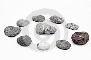 Close up of circle of pebbles or stones or sea stones with a big stone in between them.Concept of unity,integrity, recycling,and E