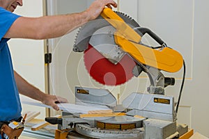 Close up of Circular saw cutting sharp rotary blade new baseboard woodwork