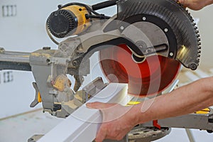 Close up of Circular saw cutting sharp rotary blade new baseboard woodwork