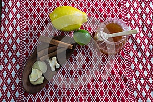 Citrus fruit , cinnamon sticks and honey on a place mat