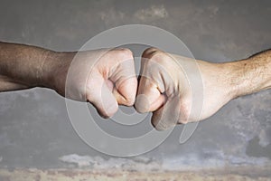 Close up clash of two fists on dramatic background