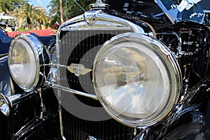 Close up classic car's stylish headlamps and grill