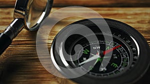 Close-Up of a Classic Compass Beside a Rope on a Wooden Surface During Daylight