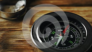 Close-Up of a Classic Compass Beside a Rope on a Wooden Surface During Daylight