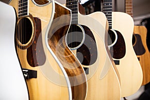 Close up of classic guitar drapped in a row in a huge musical shop, instrument shop, instrument concept