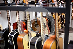 Close up of classic guitar drapped in a row in a huge musical shop, instrument shop, instrument concept