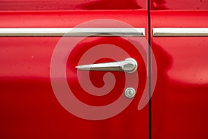 Close up of classic red car door handle..