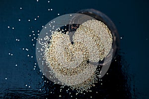 Close up of clay bowl on wooden surface full of Poppy seeds or khus or opium poppy or breadseed poppy.