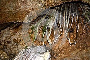 Close-up of clay stalactites in an underground cave. Speleological research and study of caves