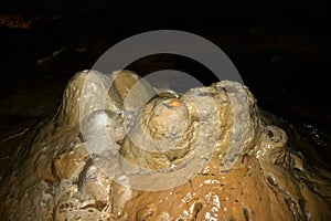 Close-up of clay stalagmites rising from the floor of an underground cave. Speleological research and study of caves