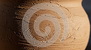 Close-up of a clay surface with textured patterns. The pottery features organic,