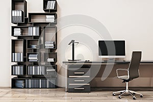 Close up of clean designer office interior with creative wooden bookcase, empty computer monitor and other items.