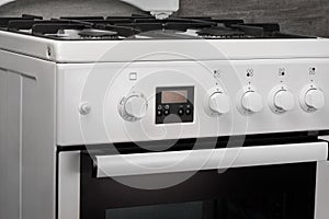 Close up of clean white kitchen gas stove on gray