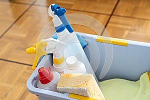 Close up of cleaning equipment in a bucket for house and home cleaning on a wooden parquet floor