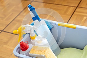 Close up of cleaning equipment in a bucket for house and home cleaning on a wooden parquet floor