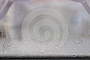 Close-up clear drops of water on window glass surface