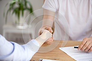 Close up of client handshake realtor buying or renting house