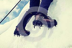 Close up of climber climbing ice mountain in mountainering  shoes