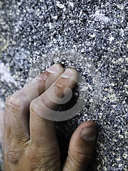 Close up of a climber griping the rock with all hes got