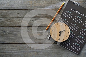 Close up of clock, calendar and pencil on the table