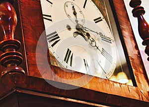 Close up of clock face on an antique grandfather clock with roman numerals