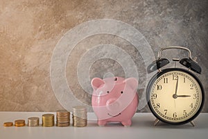 Close-up of clock and pink piggy bank smile with coins stack stair step up growing growth saving money. concept Business Finance,