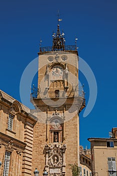 Close-up of clock tower with sunny blue sky in Aix-en-Provence.