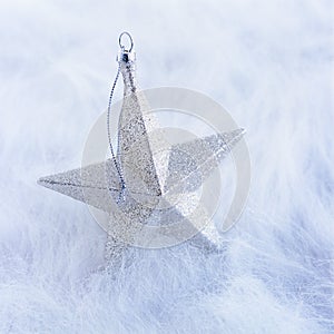 Close-up closeup of simple, modern, silver glitter star Christmas ornament decoration on white background