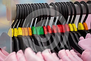 Close up of a clothing rack with hangers showing different clothing size tags