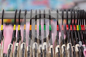 Close up of a clothing rack with hangers showing different clothing size tags