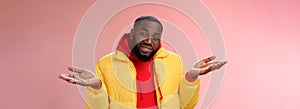 Close-up clueless unaware handsome stylish african-american bearded man in yellow jacket shrugging hands spread sideways