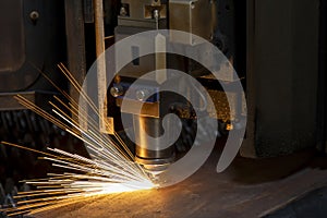 Close up cnc lasercutting of sparks fly out machine head for metal processing at the factory. Au