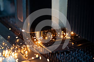 Close up cnc lasercutting of sparks fly out machine head for metal processing at the factory. Au