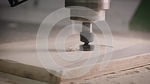 Close-up. The CNC machine cuts a piece of wood with a milling cutter.