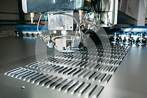 Close up of cnc punching press machine with metal plate
