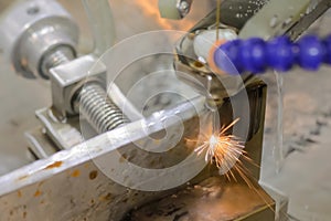 Close up: cnc wire cutting machine working with metal workpiece with sparks